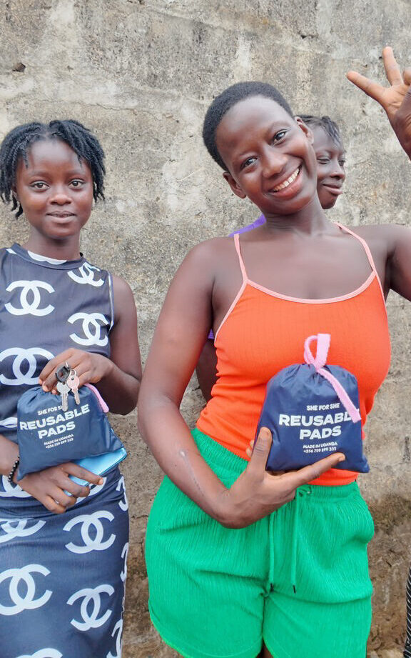 To unge kvinder i FANT Sierra Leones fællesskaber viser deres genanvendelige bind fra SheforShe pads, som er blevet doneret af OBT Shipping Group