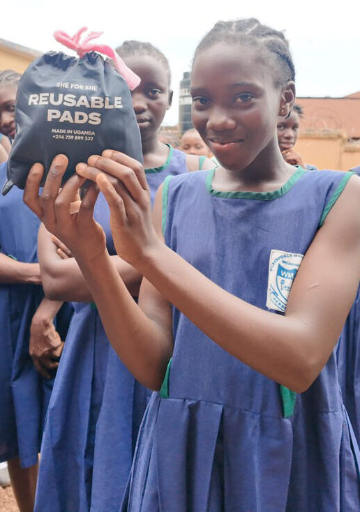 En pige i FANT Sierra Leones fællesskaber viser sit genanvendelige bind fra SheforShe pads, som er blevet doneret af OBT Shipping Group